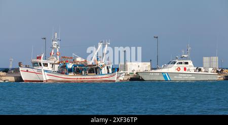 Zakynthos, Greece - August 14, 2016: Fishing boats are moored in Zante port near Coast Guard patrol boat Stock Photo