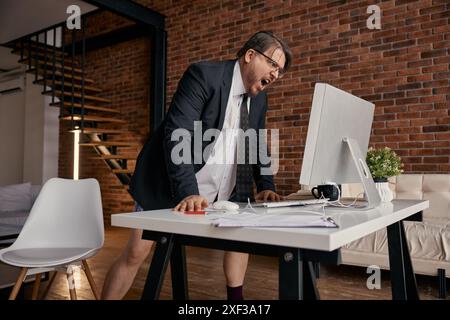 Angry businessman screaming on computer having online meeting at home office Stock Photo
