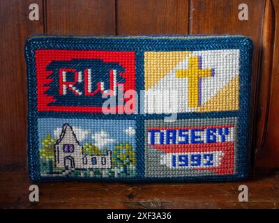 An embroidered kneeler, prayer cushion or hassock, church of All Saints in Naseby village, Northamptonshire, UK Stock Photo