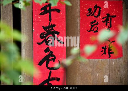 Taiwan - Jun 29, 2024: In an old street alley, a house's red spring couplets stand out, adding festive color and symbolizing hope for a better life. Stock Photo