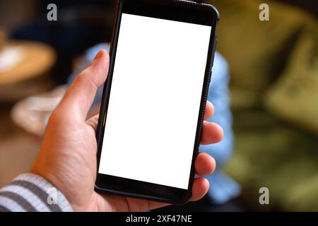 Close-up of a mobile phone in a mans hand with a blank white screen for text or custom content. Blurred background Stock Photo