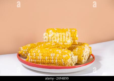 Sweet boiled corn cobs portions on plate, copy space Stock Photo