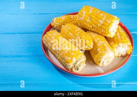 Sweet boiled corn cobs portions on plate, copy space Stock Photo