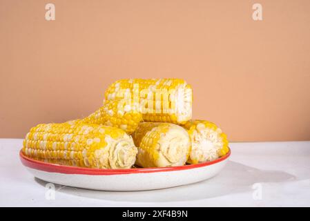 Sweet boiled corn cobs portions on plate, copy space Stock Photo
