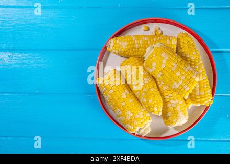 Sweet boiled corn cobs portions on plate, copy space Stock Photo