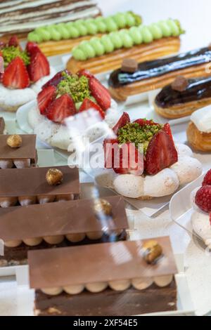 Various Sweets and Pastries Displayed on Shelves in a French Bakery Stock Photo