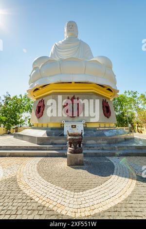 Bottom view of giant white Buddha statue on blue sky background at Hai Duc Pagoda in Nha Trang, Khanh Hoa province of Vietnam. Stock Photo