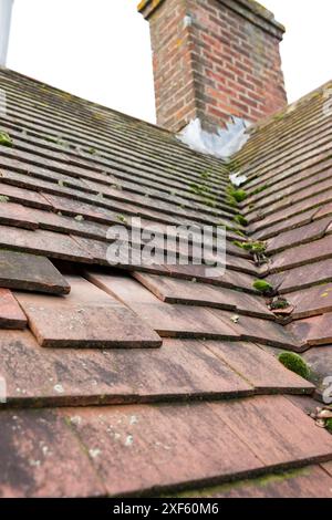 Missing and slipped plain clay roof tiles on a pitched roof of an old house in England, UK Stock Photo