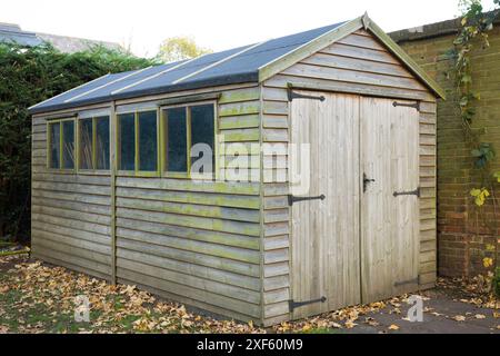 Wooden garden shed with new replacement felt roof. Part of a series showing a felt roof being replaced on a shed in a UK garden. Stock Photo