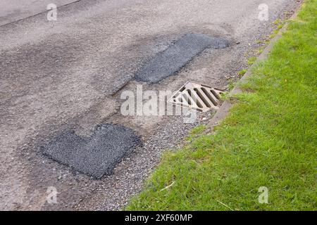 Pothole patch repairs on a country road in disrepair. UK road maintenance. Buckinghamshire, UK Stock Photo