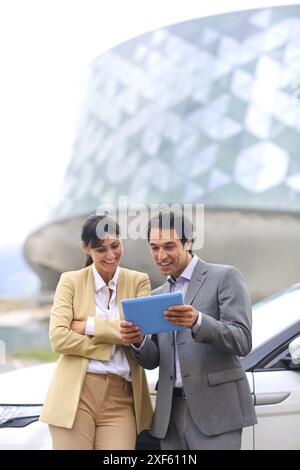 Business man and woman with tablet in parking business center. San Sebastian Technology Park. Donostia. Gipuzkoa. Basque Country. Spain. Stock Photo