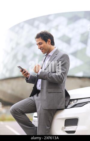 Business man with smartphone in parking business center. San Sebastian Technology Park. Donostia. Gipuzkoa. Basque Country. Spain. Stock Photo