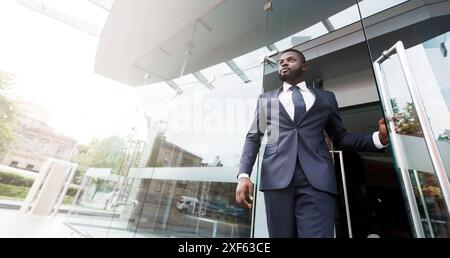 Young african job seeker leaving building after interview Stock Photo