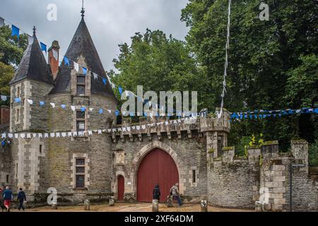 A view of the medieval Josselin Castle decorated with banners, located in Josselin, Brittany, France. The castle exudes historic charm and is surround Stock Photo