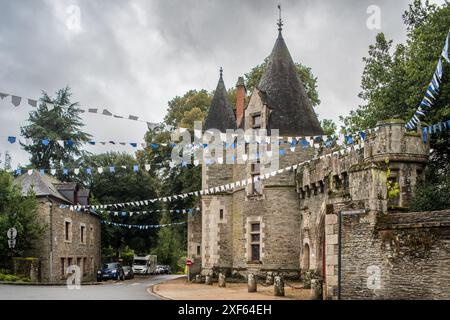 Charming view of the historic Josselin Castle adorned with festive flags in the picturesque town of Josselin, Brittany, France. Stock Photo