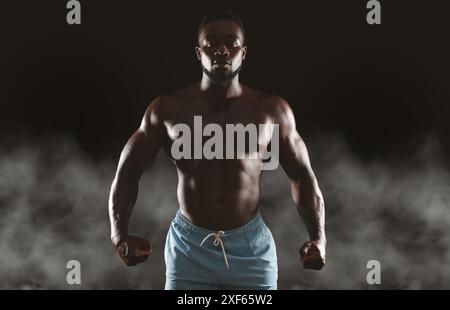 Muscular Man Posing in Smoke Stock Photo