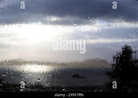 Raindrops running down a window pane Stock Photo