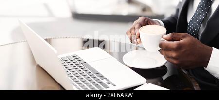 Unrecognizable Businessman Having Coffee Working On Laptop In Cafe, Closeup Stock Photo