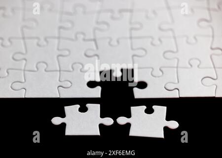 A puzzle piece is missing from a puzzle. Concept of loss and emptiness, as the puzzle is incomplete without the missing piece Stock Photo