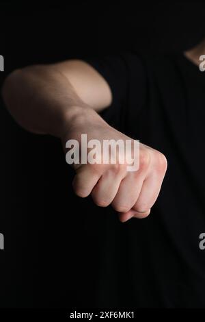 Man showing fist with space for tattoo on black background, closeup Stock Photo