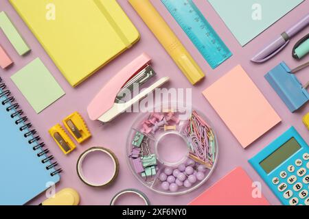 Flat lay composition with notebooks, stapler and different stationery on violet background Stock Photo