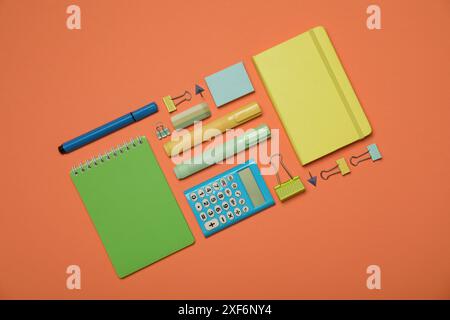 Flat lay composition with notebooks and different stationery on orange background Stock Photo