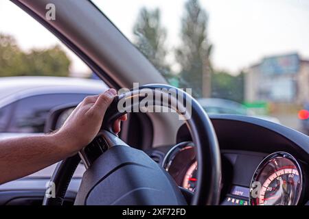 male driver is driving in a passenger car during a traffic jam yesterday. driving on the left Stock Photo