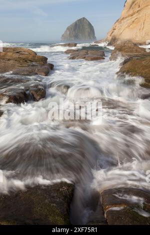 USA, Oregon. Waves in front of Haystack Rock, Cape Kiwanda State Park. Stock Photo