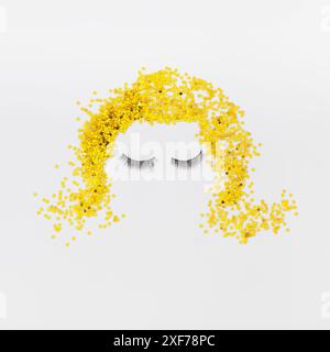 Creative blonde girl's face made with false eyelashes and golden glitter stars confetti on white background. Retro fashion beauty style aesthetic. Stock Photo