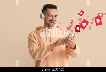 Happy man using mobile phone for online dating on beige background Stock Photo