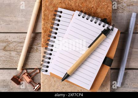 Pen, notebooks, binder clips and markers on wooden background Stock Photo