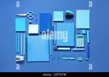 Notebooks and different stationery on blue background Stock Photo