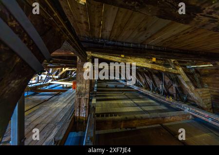 The roof truss of Bremen's Old Town Hall has a special structural feature. One of two independent structures supports the copper roof and the other the ceiling of the Upper Hall. In this way, the tensile forces that would normally load the roof truss are absorbed by the weight of the ceiling and distributed to the outer walls. This engineering solution ensures exceptional stability and longevity of the historic roof truss. Bremen, Germany Stock Photo