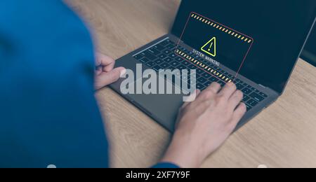 user is using computer with system warning caution sign for notification error. hacker attacks and hacking data, cyber crime, cyber security, Spyware. Stock Photo