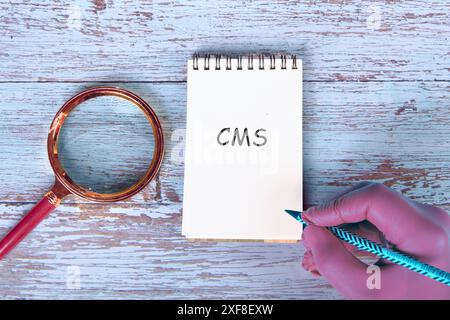 CMS (Content Management System) acronym It is written in the notebook by hand Stock Photo