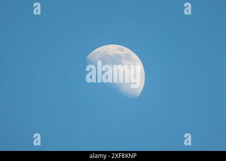 The Moon is in the blue sky on a daytime, close-up view, natural astronomic photo Stock Photo