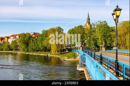 Elk, Poland - May 3, 2024: Panoramic view of Elk town with historic bridge and Holiest Heart of Jesus neo gothic church at Jezioro Elckie Lake Stock Photo