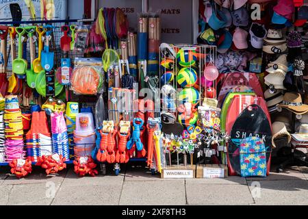 Colourful colorful plastic beach toys on sale on the pavement sidewalk outside a shop store in Newquay in Cornwall in the UK. Stock Photo