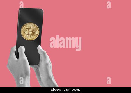 Black and white hands holding a smartphone displaying a gold bitcoin logo, conveying concepts of cryptocurrency investment and digital finance Stock Photo