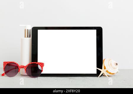 Flat lay composition with tablet and beach accessories on colored background. Tablet computer with blank screen mock up with copy space. Stock Photo