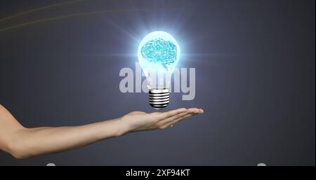 Image of human brain spinning inside a electric bulb over cupped hand against grey background Stock Photo