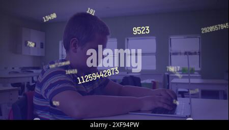 Image of multiple changing numbers against caucasian boy using laptop in class at school Stock Photo