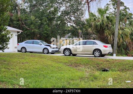 Dented car damaged after traffic accident parked on private home driveway Stock Photo