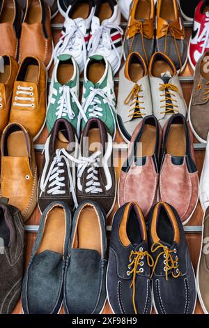 Variety of casual men shoes on shelves in shoe shop. Set of different men's shoes. Shoes of different types of close-up. Men's shoes of different seas Stock Photo