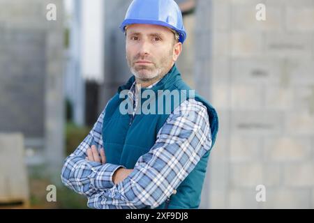 worker in factory portrait with woman driving forklift in background Stock Photo