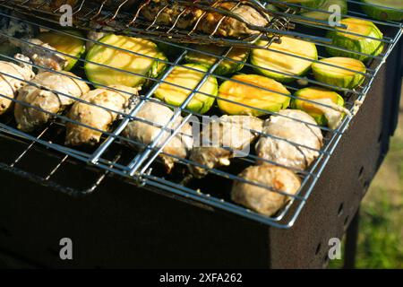 Healthy summer cooking: grilled zucchini and vegetables on a BBQ. Grilled zucchini and assorted vegetables on a summer picnic Stock Photo