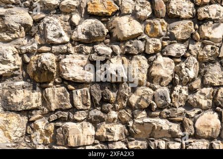 Texture of old stone wall with big boulders of limestone in different pastel colors. Stock Photo