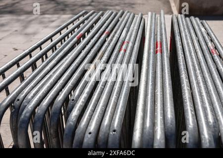 Row of metal fencing is stacked on top of each other. The fencing is red and white, and it is old and rusted. The image gives off a sense of abandonme Stock Photo