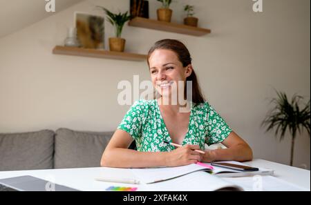 Woman adult student smiling while studying at home. Stock Photo