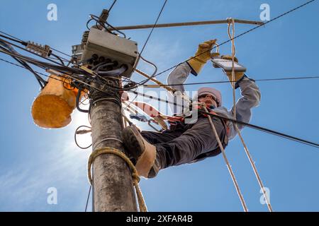 electrical technician performs maintenance to public lighting using all industrial safety elements. Stock Photo
